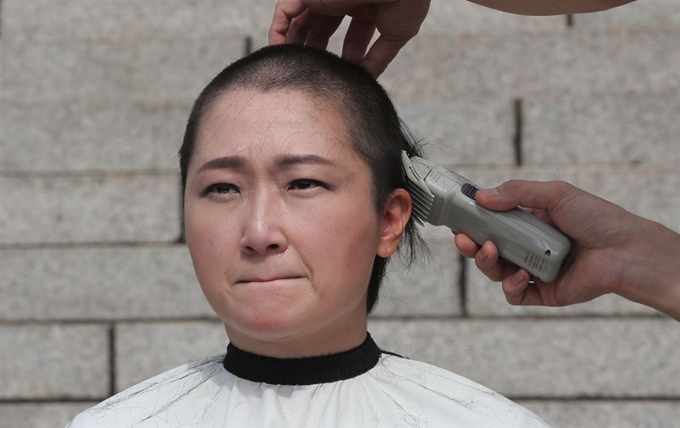 이언주 무소속 의원이 10일 국회 본청 앞 계단에서 조국 법무부 장관 임명 철회와 대국민 사과를 요구하는 기자회견을 마친 뒤 삭발하고 있다. 연합뉴스