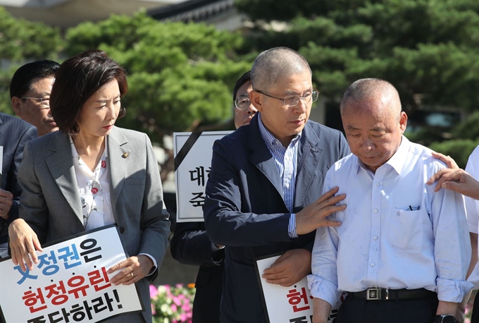 자유한국당 황교안 대표가 18일 오전 서울 종로구 청와대 분수대 광장 앞에서 조국 법무부 장관의 사퇴 촉구 삭발한 이주영 국회부의장을 격려하고 있다. 왼쪽 두번째부터 나경원 원내대표, 황교안 당대표, 이주영 국회부의장, 심재철 의원. 뉴시스