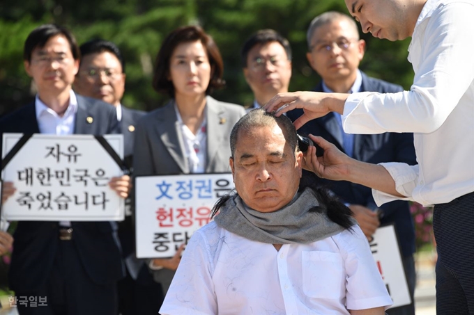 자유한국당 심재철 의원이 18일 오전 서울 청와대 분수대 앞에서 조국 법무부 장관 사퇴를 촉구하며 삭발하고 있다. 오대근기자