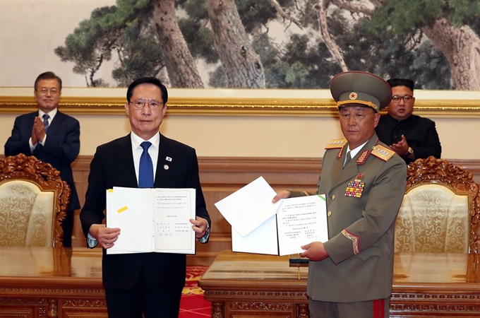 문재인 대통령과 김정은 국무위원장이 지난해 9월 19일 백화원 영빈관에서 송영무 국방부 장관과 노광철 인민무력상의 판문점선언 이행을 위한 군사분야 합의문을 교환을 지켜보며 박수를 치고 있다. 평양사진공동취재단