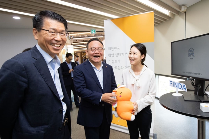 은성수(왼쪽) 금융위원장이 18일 서울 강남구 디캠프에서 열린 핀테크 스케일업 현장간담회에서 스타트업 관계자로부터 혁신금융서비스에 관한 설명을 듣고 있다. 금융위원회 제공