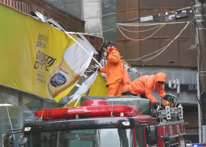 제17호 태풍 타파가 북상중인 22일 오후 전남 여수시 여서동 한 거리에서 거센 바람에 간판이 떨어져나가 소방당국이 안전조치를 하고 있다. 연합뉴스