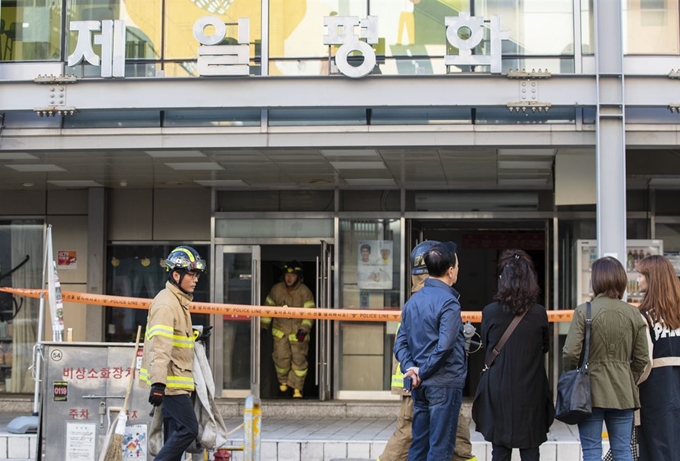 화재 발생 하루가 지난 23일 오전 서울 중구 제일평화시장 앞에서 상인들이 피해 상황을 살피고 있다. 연합뉴스