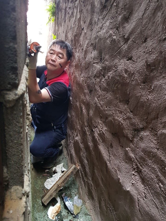 박진관 보냉가설봉사단장이 부산 사하구의 한 동네에서 집수리를 하고 있다.