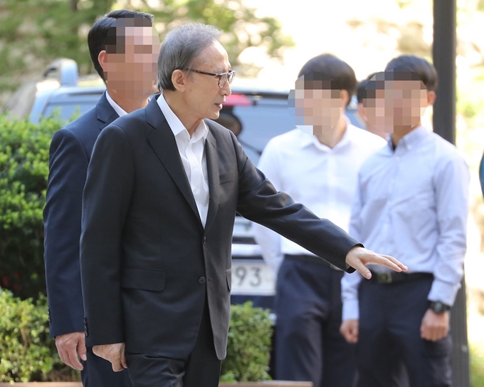 이명박 전 대통령이 23일 오전 서울 서초구 서울고등법원에서 열린 속행 공판에 출석하며 지지자들에게 인사하고 있다. 연합뉴스