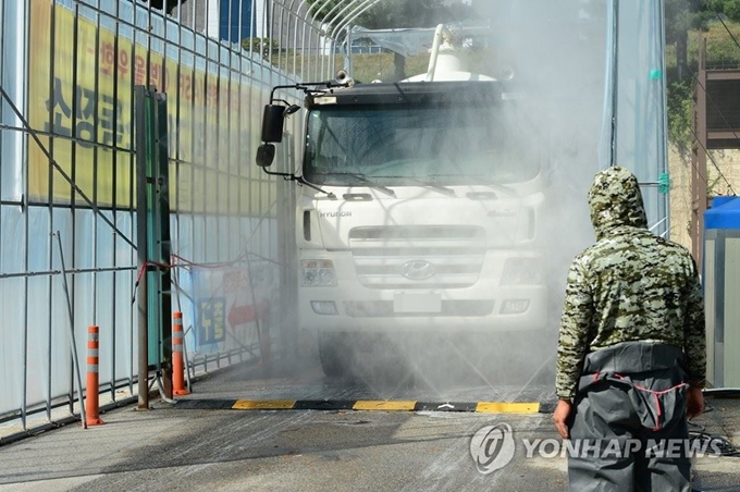 충남 홍성 홍주종합경기장 거점소독시설에서 아프리카돼지열병(ASF) 확산 차단을 위한 차량 소독이 이뤄지고 있다. 연합뉴스.