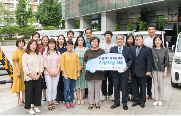 강승중 한국수출입은행 전무이사(앞줄 오른쪽에서 세 번째)와 김연순 사랑의열매 사무총장이 다문화가족지원단체에 차량 8대를 기증한 후 기념촬영하고 있다.