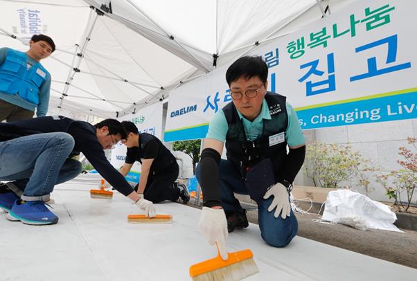 대림산업 박상신 대표(맨 오른쪽)가 도배작업에 사용할 벽지에 풀칠을 하고 있다.