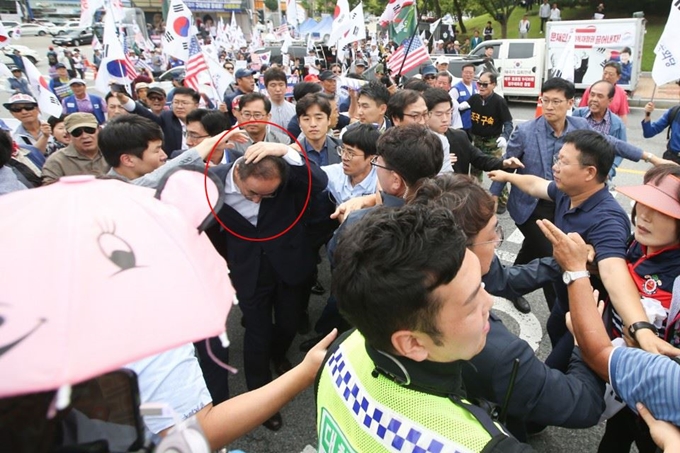 보수단체 회원들이 25일 오후 구미시청 앞에서 구미공단 50주년 기념 홍보영상에 박정희 전 대통령이 빠진 점을 항의하며 장세용 구미시장(붉은색 동그라미)의 사퇴를 요구했다. 이들은 공무원들과의 몸싸움 과정에서 태극기 깃대로 장시장의 머리를 때리는 등 소란을 피웠다. 연합뉴스