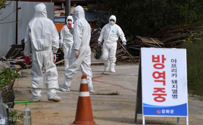 인천 강화군 한 양돈농장에서 국내 다섯 번째로 아프리카돼지열병(ASF)이 확진된 것으로 알려진 25일 인천시 강화군 송해면 해당 농장에서 방역관계자가 검사를 마치고 나오고 있다. 강화=서재훈 기자