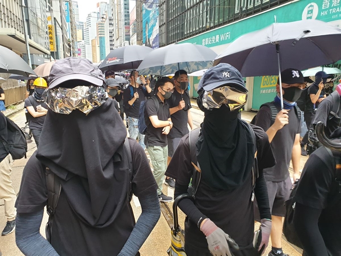 홍콩 시위대가 마스크 착용은 물론이고 눈까지 가려 ‘울트라맨’을 연상시키는 복장으로 서 있다. 경찰의 감시 카메라에 신원이 노출되는 것을 완벽하게 차단하기 위해서다. 김광수 특파원