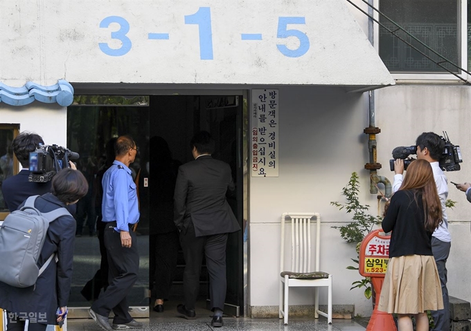 검찰이 서울 방배동 조국 법무부 장관 자택을 압수수색 한 지난 23일 오전 검찰 관계자로 추정되는 남성들이 조 장관이 사는 아파트 현관으로 들어가고 있다. 이한호 기자