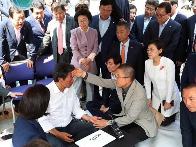 황교안 대표가 30일 오후 국회 본청 앞에서 '조국 임명' 에 반발해 단식 농성 중인 이학재 의원을 찾아 병원 이송을 권유하고 있다. 연합뉴스