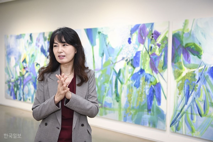 안진의 교수가 서울 강남구 갤러리두인에서 이번 개인전 '꽃의 시간 : 꽃 앞에서 꽃을 그리워하다'에 내건 작품들을 설명하고 있다. 이한호 기자