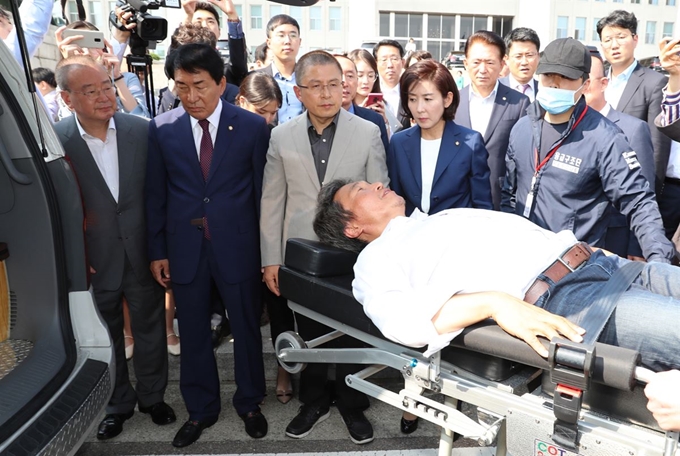 국회 본청 앞에서 단식 투쟁 중인 이학재 자유한국당 의원이 지난달 30일 오후 동료 의원들에 의해 강제로 병원으로 이송되고 있다. 연합뉴스