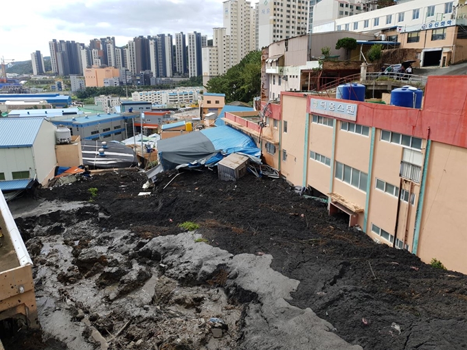 3일 오전 부산 사하구 구평동의 한 야산에서 산사태가 발생, 주택과 식당 등 건물 2채를 덮쳤다. 부산소방본부 제공