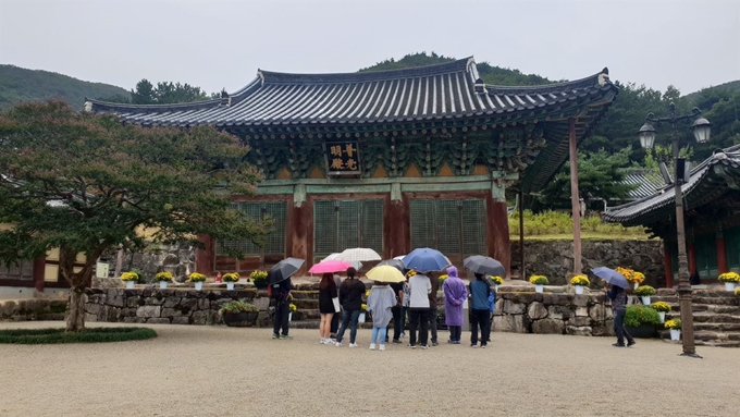 관광객들이 위봉사 대웅전 앞에서 해설사 설명을 듣고 있다.