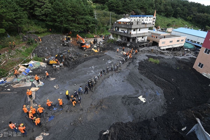 3일 오후 부산 사하구 구평동의 한 야산에서 산사태가 발생, 토사가 쏟아지면서 주택 1채와 식당 1개동 등을 덮쳐 4명이 매몰돼 소방대원과 군 장병 등이 굴착기 등 중장비를 동원해 토사 제거와 함께 수색작업을 펼치고 있다. 부산=전혜원 기자