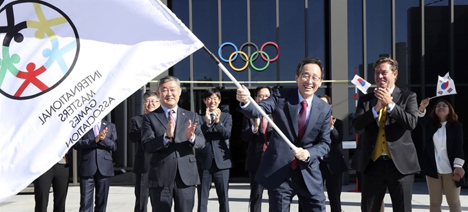 송하진 전북지사가 지난 2일 스위스 로잔 올림픽박물관에서 ‘2022 아ㆍ태마스터스대회’ 개최지로 전북도가 확정된 후 옌스홀름 IMGA 사무총장에게 대회기를 받아 힘차게 흔들고 있다. 전북도 제공.