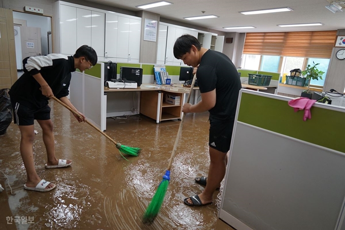 경북 영덕군 강구면 강구정보고등학교 1학년 권효담(왼쪽)군과 이재민군이 태풍 '미탁'으로 내린 많은 비로 3일 오전 침수된 학교를 찾아 흙탕물이 남아 있는 교무실을 청소하고 있다. 영덕=김정혜기자 kjh@hankookilbo.com