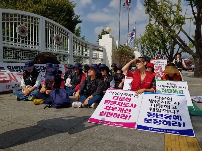 강연(왼쪽 두번째) 전국다문화가정방문교육지도사협회 대표를 비롯한 다문화가정방문교육지도사들이 지난 4일 오후 정부서울청사 앞에서 정년유예를 요구하며 피켓을 들고 있다. 신혜정 기자.