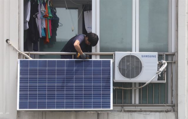 서울시내 한 아파트에서 태양광 미니발전소 보급업체가 베란다에 태양광 모듈을 설치하고 있다. 연합뉴스