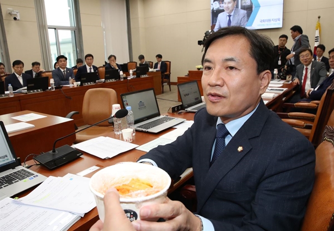 7일 국회에서 열린 정무위원회 국정감사에서 자유한국당 김진태 의원이 조성욱 공정위원장에게 국대떡볶이를 들어 보이며 프랜차이즈 업체 관련 질의하고 있다. 연합뉴스