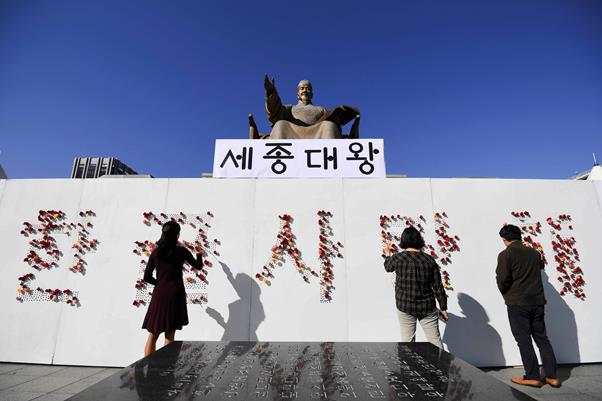 시민들이 8일 오후 서울 종로구 광화문광장에서 열린 573돌 한글날 시민 꽃 바치기 행사에서 ‘한글 사랑해’라는 문구에 꽃을 꽂고 있다. 박형기 인턴기자