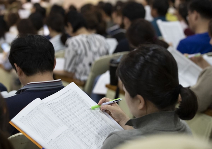 지난 8월 서울 강남구 진선여고에서 열린 ‘자사고 재지정 여파 현 고1부터 수능 대폭변화 상위권 학생 고교선택전략 설명회’에서 참석자들이 관련 자료를 보고 있다. 연합뉴스