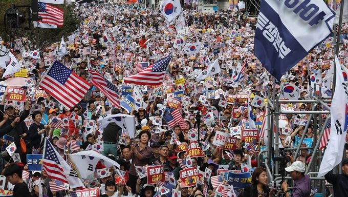 지난 3일 낮 서울 광화문 교보빌딩 앞에서 열린 ‘문재인 하야 범국민투쟁 대회’에서 참석 시민들이 태극기와 성조기를 흔들며 구호를 외치고 있다. 연합뉴스