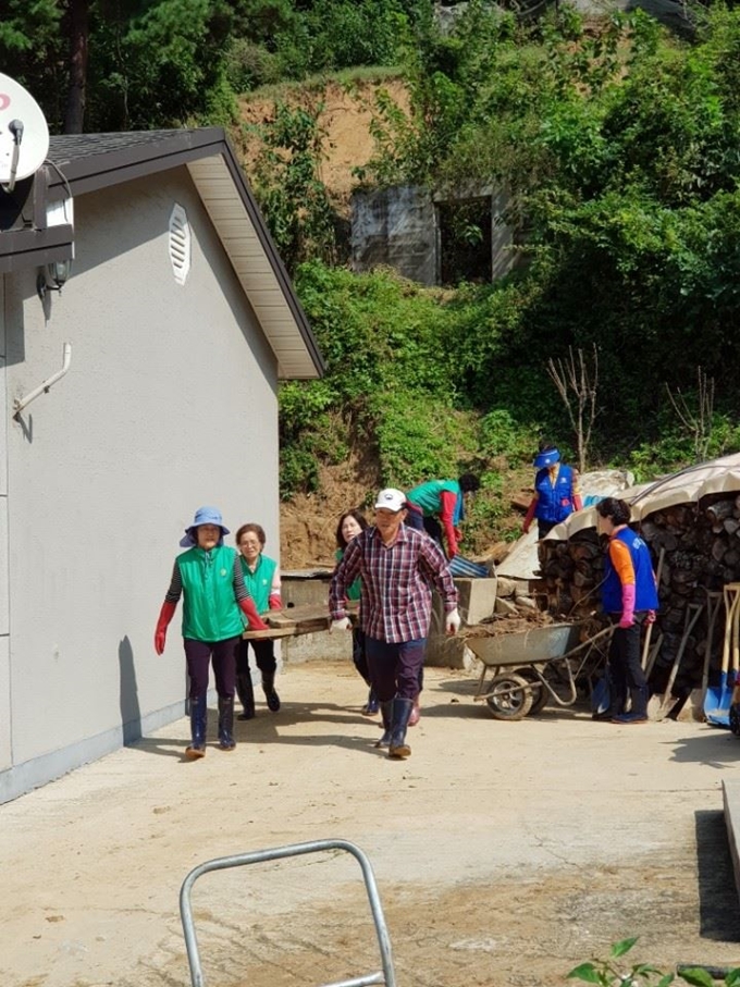 경북 울진군 자매도시인 부산 동구 공무원과 주민들이 태풍 '미탁'으로 큰 피해를 입은 울진을 찾아 침수 가구의 복구를 돕고 있다. 울진군 제공