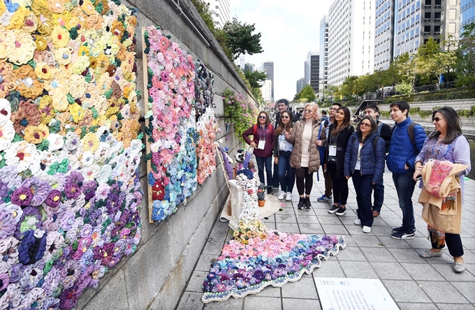 15일 서울 청계천 청계광장에서 열린 '제5회 청계천 업사이클 페스티벌 류'에서 대한민국 정부 초청 콜롬비아 정부 공무원들이 폐자원·폐자재를 활용해 만든 예술 작품을 살펴보고 있다.배우한 기자