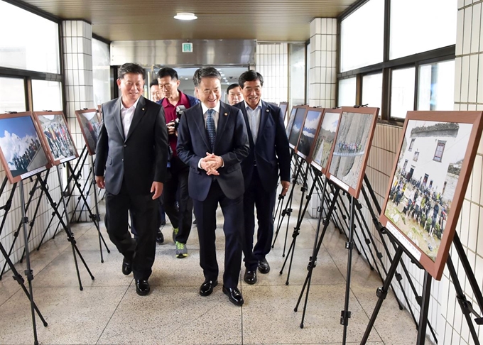 안산시 줌마탐험대의 히말라야 여정을 담은 사진들이 안산시청 2층 대회의실 앞에 전시된 가운데 지난 15일 시청을 찾은 박능후(앞줄 가운데) 보건복지부 장관과 윤화섭(앞줄 오른쪽) 안산시장 등이 사진을 둘러보고 있다. 안산시 제공