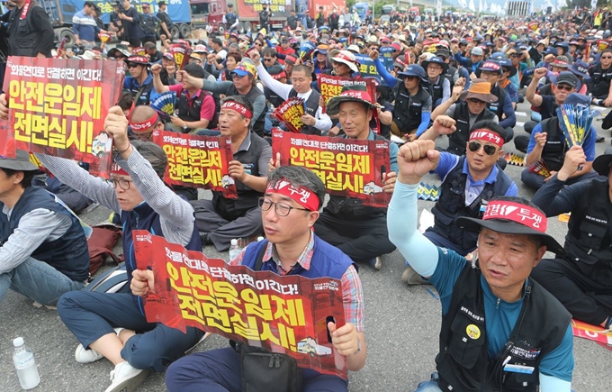 지난 6월 부산 강서구 부산항 신항에서 열린 '화물연대 총력투쟁 결의대회'에서 화물기사들이 안전운임제 전면 실시를 요구하고 있다. 연합뉴스