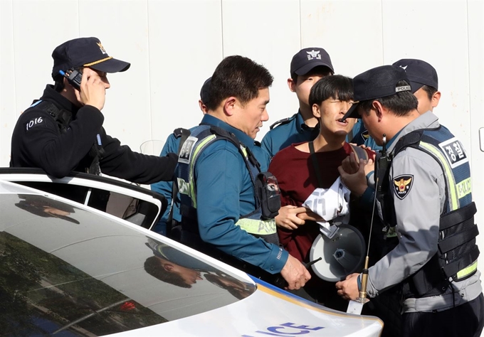 18일 서울 정동 주한미국대사관저 앞에서 주한미군 방위비 인상을 반대하며 담장을 넘으려던 한국대학생진보연합 학생을 경찰이 연행하고 있다. 뉴시스