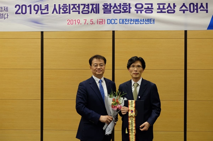 지난 7월 5일 대전 수성구 대전컨벤션에서 열린 '2019 사회적경제 활성화 유공 포상 수여식'에서 대통령 표창을 수상한 이지무브의 오도영 대표(오른쪽)와 방기선 기획재정부 차관보가 기념촬영을 하고 있다. 이지무브 제공