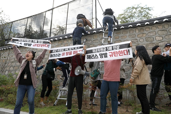 한국대학생진보연합 소속 대학생이 18일 오후 서울 중구 주한 미국대사관저에서 방위비분담금 협상 관련 기습 농성을 하기 위해 담벼락을 넘고 있다. 뉴시스