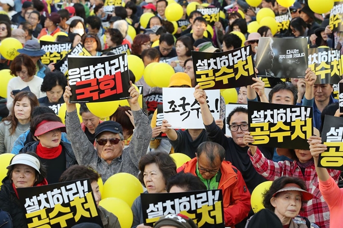 19일 오후 서울 여의도 국회 앞에서 열린 '사법적폐청산을 위한 제10차 검찰개혁 촛불문화제'에서 참가자들이 촛불을 들고 공수처 설치, 검찰개혁 법안 통과 등을 촉구하는 손팻말을 들고 있다. 연합뉴스