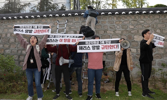 한국대학생진보연합 소속 대학생이 18일 오후 서울 중구 주한 미국대사관저에서 방위비분담금 협상 관련 기습 농성을 하기 위해 담벼락을 넘고 있다. 뉴시스