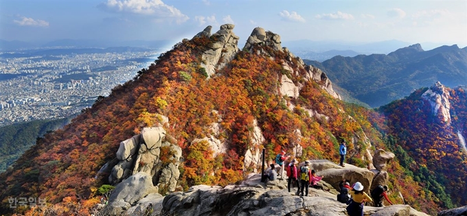 19일 북한산 만경대 단풍이 절정을 이뤄 등산객들이 울긋불긋한 단풍잎을 보며 산을 오르며 가을 정취를 만끽하고 있다.배우한 기자