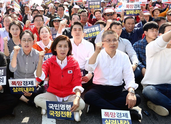 19일 오후 서울 종로구 세종문화회관 앞에서 열린 자유한국당의 ‘국민의 명령! 국정 대전환 촉구 국민보고대회’에서 황교안 대표와 나경원 원내대표가 나란히 앉아 구호를 외치고 있다. 배우한 기자