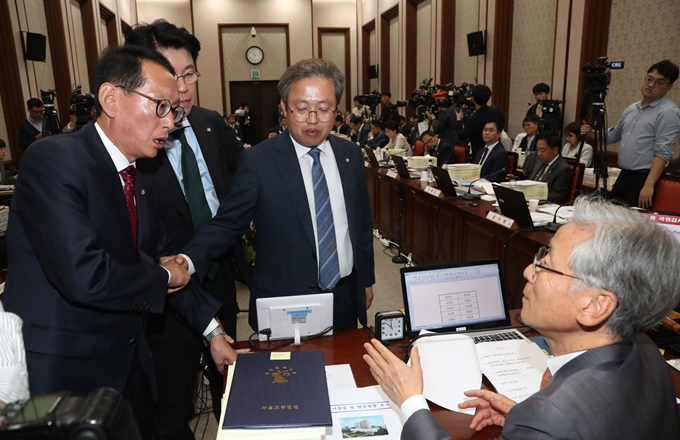 14일 서울고등법원에서 열린 국회 법사위 국정감사에서 여야 간사인 자유한국당 김도읍 의원과 더불어민주당 송기헌 의원이 명재권 판사 증인 출석 문제를 두고 여상규 위원장과 논의하고 있다. 연합뉴스