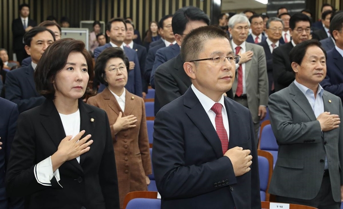 황교안(앞줄 왼쪽 두번째) 자유한국당 대표와 나경원(첫번째) 원내대표 등 의원들이 22일 국회에서 열린 의원총회에서 국기에 대한 경례를 하고 있다. 연합뉴스