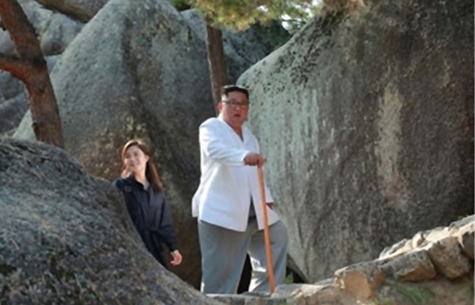 김정은 북한 국무위원장이 금강산관광지구를 현지 지도하고 금강산에 설치된 남측 시설 철거를 지시했다고 조선중앙통신이 23일 보도했다. 김 위원장이 넉 달 가까이 공개석상에 모습을 드러내지 않은 리설주 여사와 걷고 있다. 고성=조선중앙통신 연합뉴스