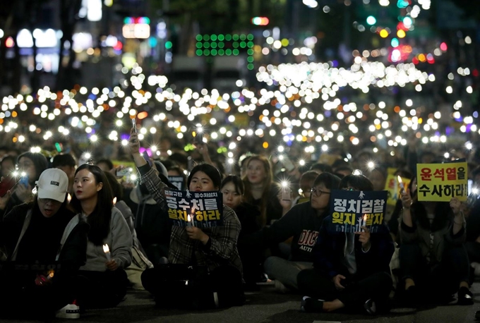 19일 오후 서울 서초구 서울중앙지법 인근 서초대로에서 열린 검찰 규탄 촛불집회에서 참가자들이 휴대전화 플래시를 켜 흔들고 있다. 연합뉴스