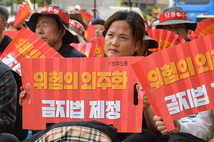 23일 오후 세종로소공원에서 열린 민주노총 위험의 외주화 금지법 제정 촉구 결의대회에 참가한 고 김용균씨 어머니 김미숙씨가 김명환 민주노총 위원장의 발언을 들고 있다.윤소정 인턴기자