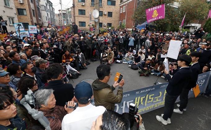 23일 오후 서울 관악구 인헌고 앞에서 '인헌고등학교 학생수호연합' 소속 학생들이 일부 교사가 '편향적 정치사상'을 학생들에게 주입했다고 주장하는 기자회견을 열고 발언을 하고 있다. 보수 유튜버와 보수단체 회원들이 학생들의 발언을 지켜보고 있다. 뉴스1