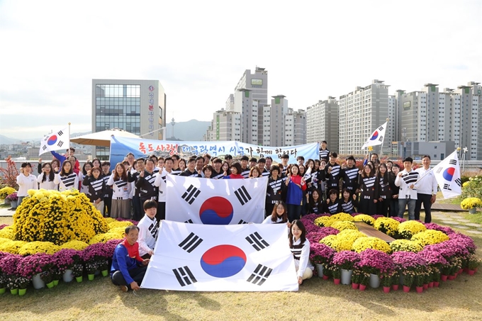 류한국 서구청장과 서구청 공무원들이 25일 독도의 날을 맞아 구청 본관 옥상 생태공원에서 대형 태극기를 펼쳐 독도수호 의지를 다지고 있다. 서구청 제공.