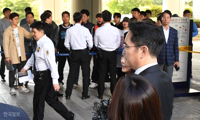 이재용 삼성전자 부회장이 25일 오전 서울 서초구 서울고등법원에서 열린 파기환송심 첫 공판에 출석하며 법정으로 향하는 동안 통제선 밖에서 삼성해고자들이 항의하고 있다. 오대근기자