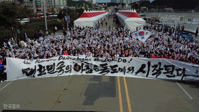 [저작권 한국일보]독도의 날인 25일 경북 포항시 영일대 해수욕장 해상 누각 광장에서 경북 지역 학생, 일반 시민 등 1,000명이 독도사랑 플래시몹을 선보이고 율산 리홍재 선생이 쓴 타묵 글씨를 들고 독도수호의지를 다지고 있다. 김재현기자 k-jeahyun@hankookilbo.com